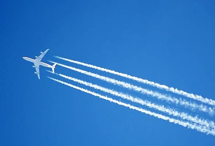 vliegtuig met viegtuigstrepen in blauwe lucht