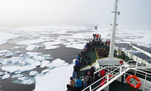 Foto van schip dat ploegt door zee-ijsvelden ten noorden van Spitsbergen op 20 augustus 2019.