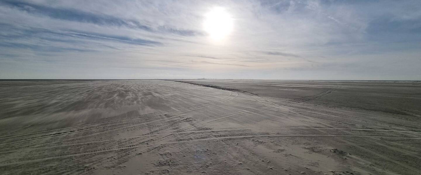 Strand onder een blauwe, zonnige hemel